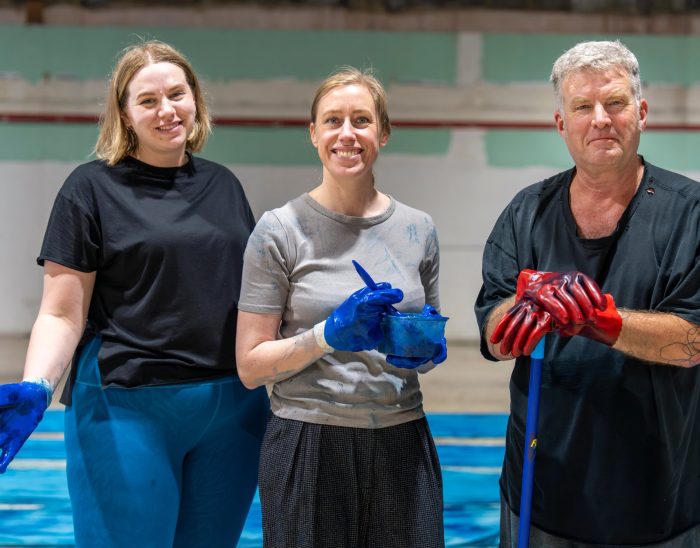 Two women and a man pose for a photo while dyeing fabric for the set of Sizewell Creative's community opera, King Arthur Reimagined